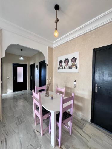a dining room with a pink table and chairs at Charmant appartement á Tanger in Tangier