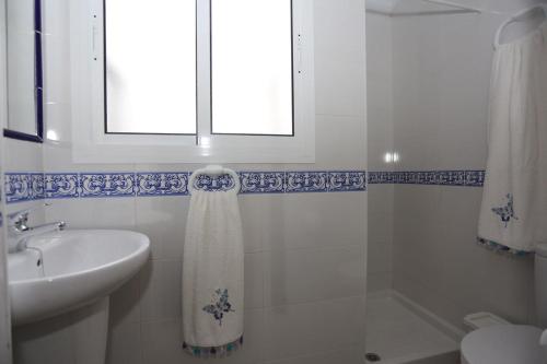 une salle de bain blanche avec un lavabo et une fenêtre dans l'établissement Casa Pepi Sánchez Conil, à Conil de la Frontera