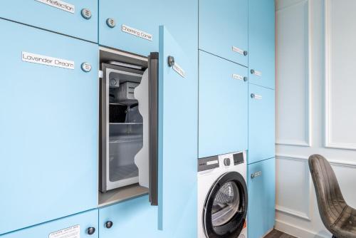 a blue laundry room with a washer and dryer at The Voyager in Upton