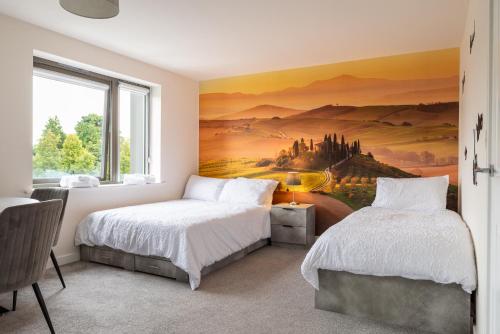 a bedroom with two beds and a painting on the wall at The Voyager in Upton