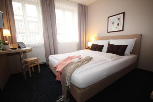 a hotel room with a bed and a desk and window at ONNO Boutique Hotel & Apartments in Rendsburg