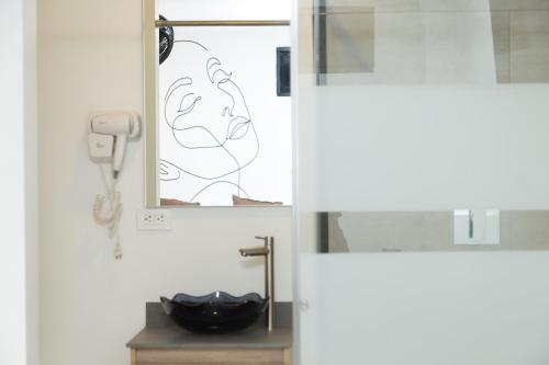 a bathroom with a mirror and a sink at Bajo la luna hotel in Medellín