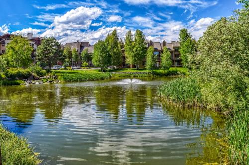 a pond in front of a building with trees at Elkhorn Springs Retreat in Sun Valley