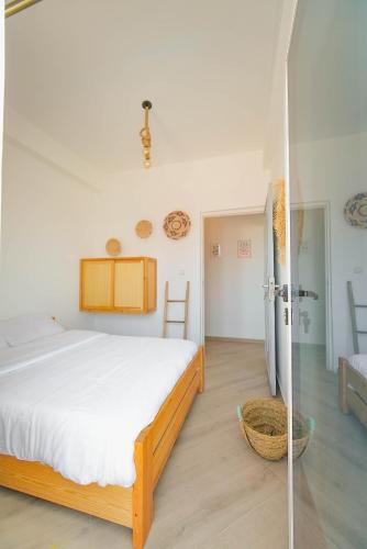 a bedroom with a bed and a glass door at Surf Break Morocco in Imsouane