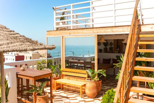 a balcony of a house with a table and a view of the ocean at Surf Break Morocco in Imsouane