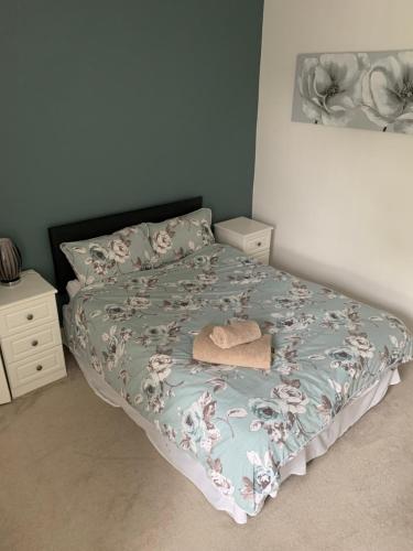 a bed in a bedroom with a bedspread with a hat on it at Apple blossom cottage contractor and holiday accommodation in Cleethorpes