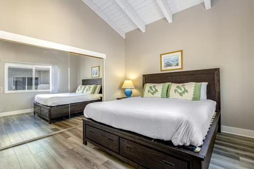 a bedroom with a large bed and a mirror at Stunning 2nd Floor Beachfront Home with Balcony, Ocean Views, and Prime Location in Newport Beach