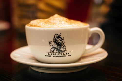 a cup of coffee on a plate on a table at The Lincoln Hotel in Lincoln