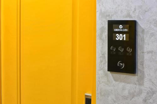 a yellow wall with a clock on the wall at Erdem City Hotel in Kaş
