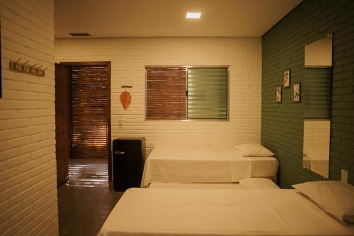 a room with two beds and a window at Pousada Egrégora in Sao Jorge