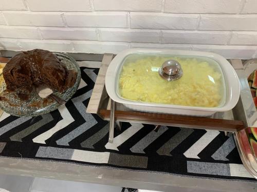 a bowl of soup on a table with a plate of food at Pousada Egrégora in Sao Jorge