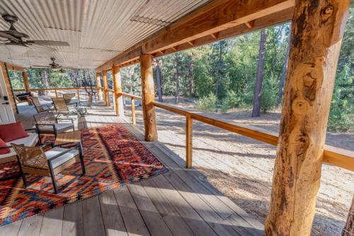 a screened porch with chairs and tables and a large window at Peppermint Falls Ranch in Ponderosa