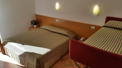 a room with two beds and a chair in it at Casa Santa Maria in Folgaria