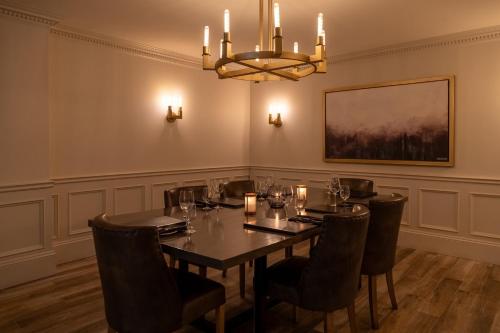a dining room with a table and chairs and a chandelier at Crowne Plaza Fredericton Lord Beaverbrook by IHG in Fredericton