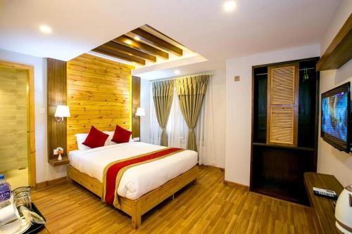 a bedroom with a large bed with red pillows at Beautiful Kathmandu Hotel in Kathmandu