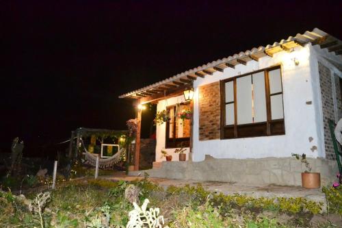a small white house at night with lights at Hospedaje San Sebastián in Monguí
