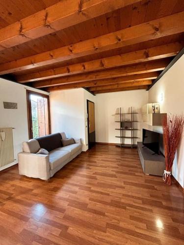 a living room with a couch and a wooden floor at Borgo Del Colle in Colle Umberto