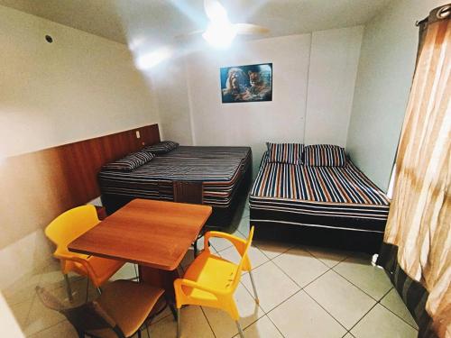 a room with two beds and a table and chairs at Thermas place 406 in Caldas Novas