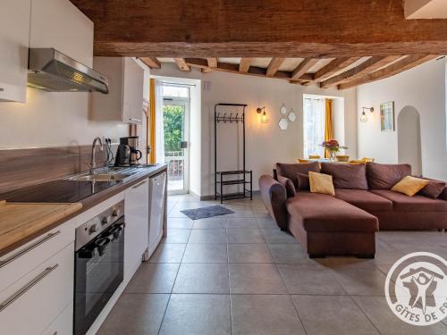 une cuisine et un salon avec un canapé dans l'établissement Gîte historique au bord de l'eau, Angers, 2 ch., tout confort, proche commodités et loisirs - FR-1-622-15, à Bouchemaine