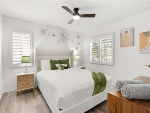 ein weißes Schlafzimmer mit einem Bett und einem Deckenventilator in der Unterkunft Irvine Inn Love - Lovely Furnished 3-bed Home in Woodbury in Irvine