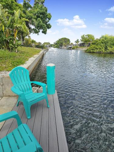 two blue chairs sitting on a dock next to the water at Dockside Delight Waterfront Gulf Access 4 mins to Beach in Englewood