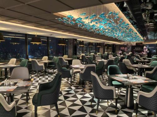 a dining room with tables and chairs and windows at Hotel Landmark Canton in Guangzhou