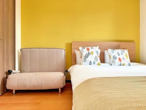 a bedroom with two beds and a chair at Juso AFP Apartment Hotel in Osaka