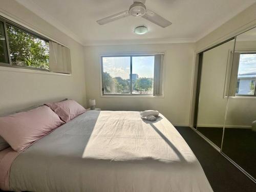 北湖Calm Hideaway - Townhouse with Pool Access & Garage的带床和吊扇的卧室