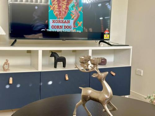 a statue of a deer sitting on a table in front of a tv at Calm Hideaway - Townhouse with Pool Access & Garage in North Lakes