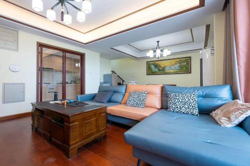 a living room with a blue couch and a table at Gubei Water Town Landscape Villa in Miyun