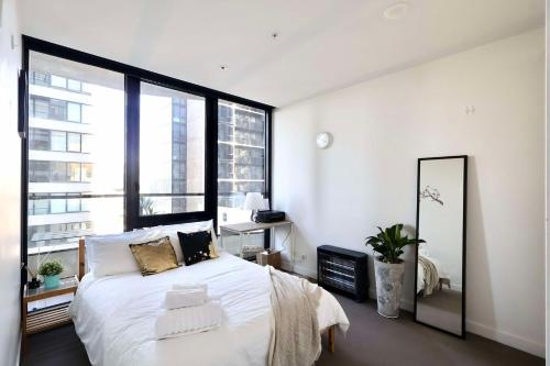 a bedroom with a large bed and a large window at Entire 1 BR Southbank Apartment - Gym Pool Sauna 1 step to Crown Casino in Melbourne
