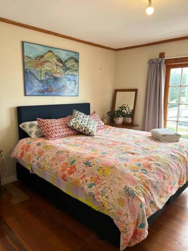 a bedroom with a large bed with pillows on it at Character Harbour Retreat in Dunedin
