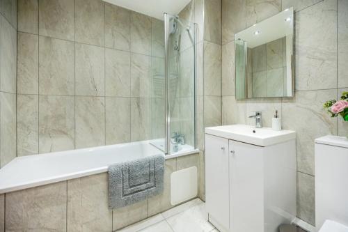 a bathroom with a tub and a sink and a shower at Classic 2bedroom Apartment in Mill Hill