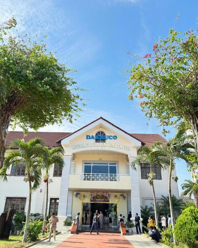 a building with people standing outside of it at Dakruco Hotel in Buon Ma Thuot