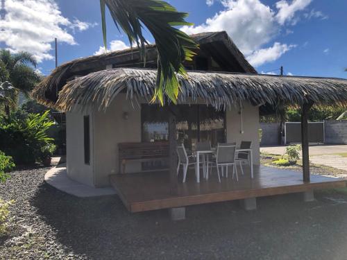 a house with a porch with chairs and a table at Faré Vanira Vairao in Matiti