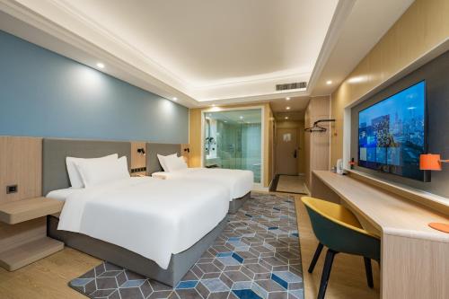 a bedroom with a large white bed and a television at Holiday Inn Express Chengdu Tianfu Square by IHG - Chunxi Road and Kuanzhai Alley in Chengdu