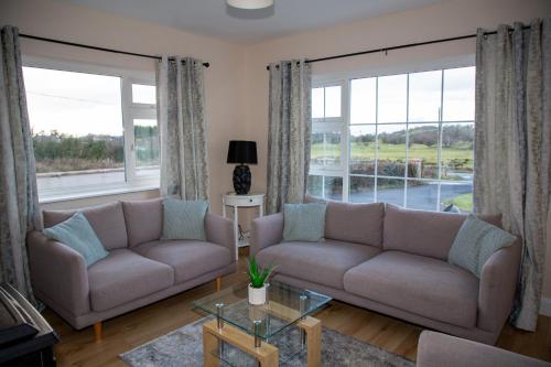 a living room with two couches and large windows at Forkfield Country House in Westport