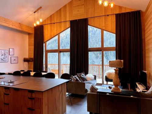 un salon avec un canapé et une grande fenêtre dans l'établissement Appartement 10 personnes Champagny-en-Vanoise, parking, animaux admis, balcon, WIFI - FR-1-638-7, à Champagny-en-Vanoise