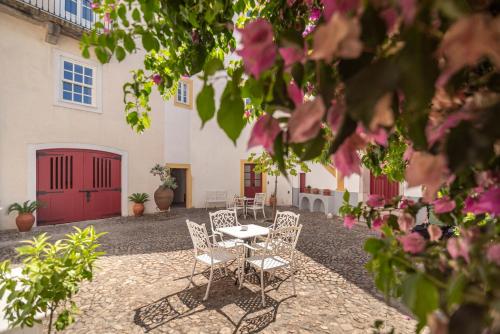 a patio with chairs and a table in front of a building at Casa Morgado Esporao in Évora