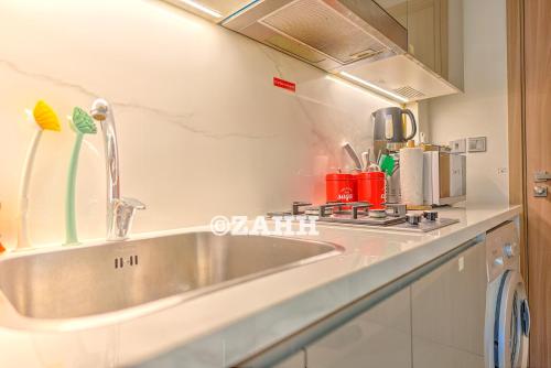 a kitchen with a stainless steel sink and a stove at Cozy Crib in Dubai