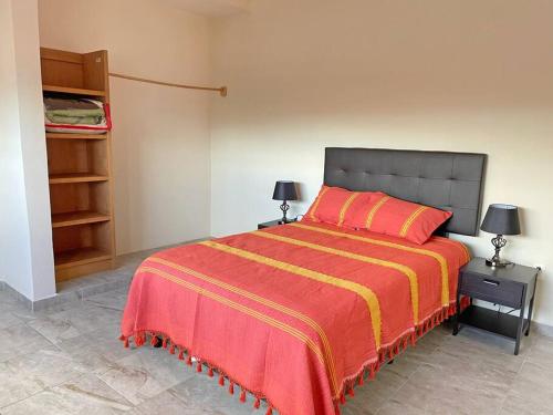 a bedroom with a bed with a red and yellow blanket at La Morada del Santuario in San Cristóbal de Las Casas