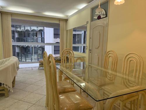 グアルジャにあるApartamento com vista marのガラスのテーブルと椅子のあるダイニングルーム