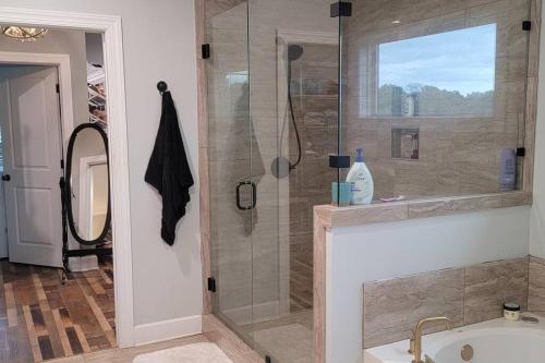 a bathroom with a glass shower with a sink at Waterfront Bama Getaway-20 min to UA in Englewood