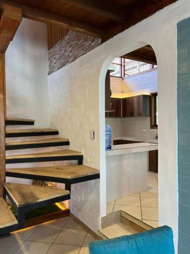 a kitchen with a stair case and a kitchen with a counter at Casa de Emmita in Puyo