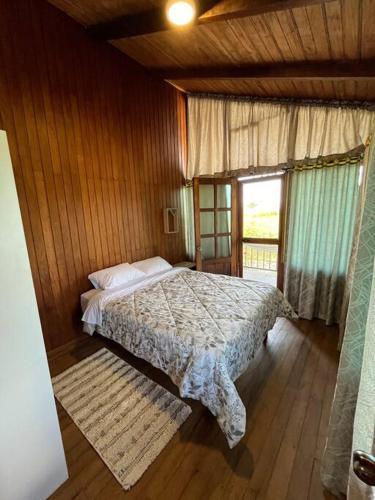 a bedroom with a bed in a wooden room at Casa de Emmita in Puyo