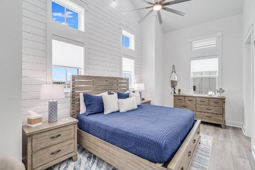 a bedroom with a blue bed and two windows at Beach Barn 108 BAR in Mustang Beach