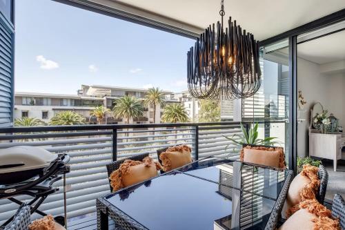 a balcony with a glass table and chairs at Balinese Charm meets Resort Living in Inner Sydney in Sydney