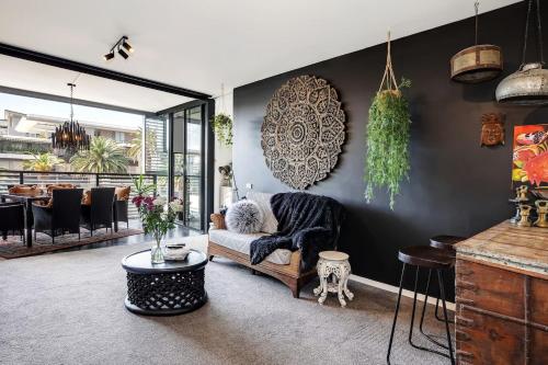 a living room with a chair and a table at Balinese Charm meets Resort Living in Inner Sydney in Sydney