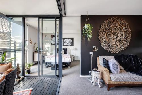 a living room with a couch and a bedroom at Balinese Charm meets Resort Living in Inner Sydney in Sydney