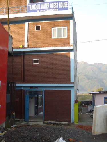 a brick building with a sign that reads trauma water guest house at Tranquil Water Guest House in Pokhara